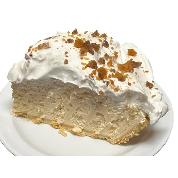 A slice of creamy pie with a graham cracker crust, topped with whipped cream and toffee bits.