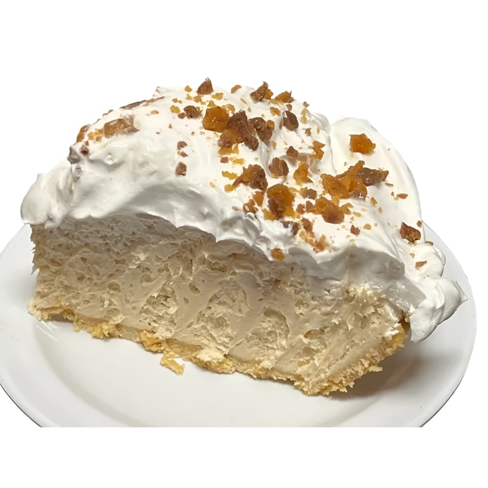 A slice of creamy pie with a graham cracker crust, topped with whipped cream and toffee bits.